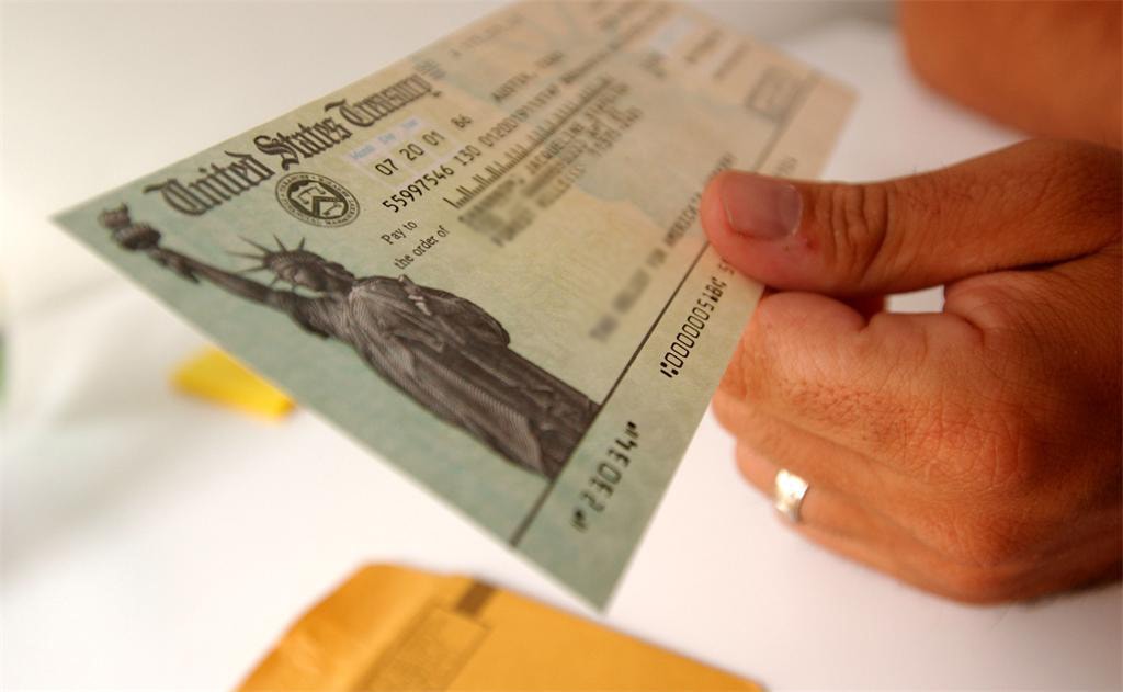 Hand holding a United States Treasury check